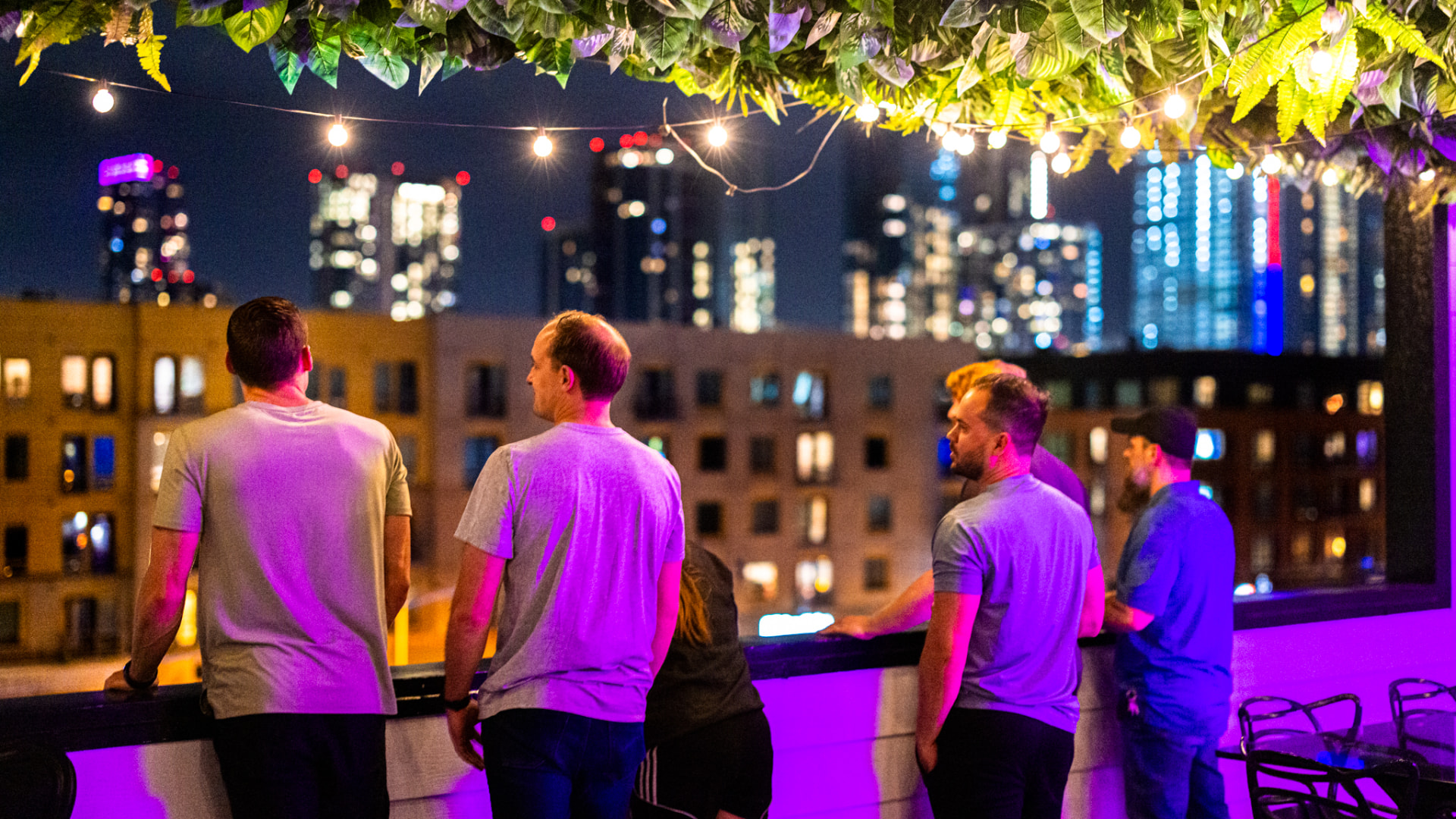 Attendees on a rooftop patio under string lights